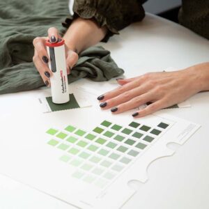 A person scanning color chips with a color reader.
