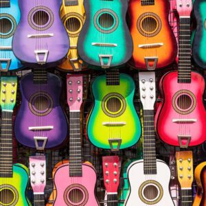 Display of multiple guitars in a variety of colors.